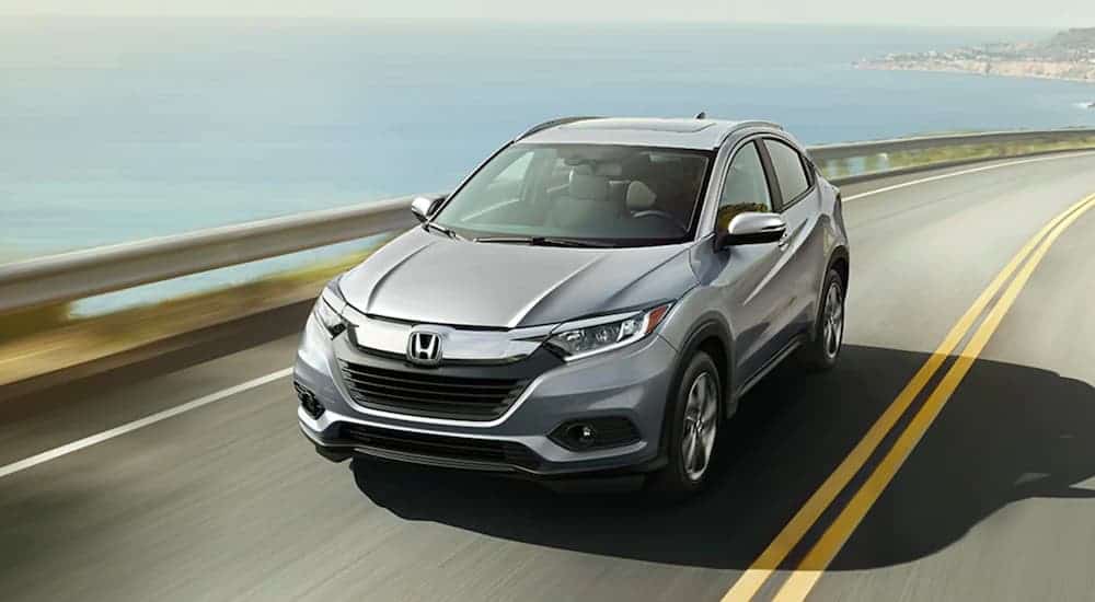 A silver 2020 Honda HR-V is driving past the ocean.