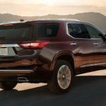 A burgundy 2020 Chevy Traverse is driving on a desert road after winning the 2020 Chevy Traverse vs 2020 Kia Sorento comparison.