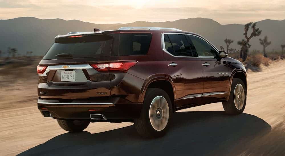 A burgundy 2020 Chevy Traverse is driving on a desert road after winning the 2020 Chevy Traverse vs 2020 Kia Sorento comparison.