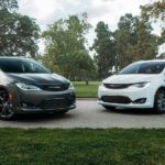 A gray 2020 Chrysler Pacifica and a white 2020 Chrysler Pacifica Hybrid are parked in a park.