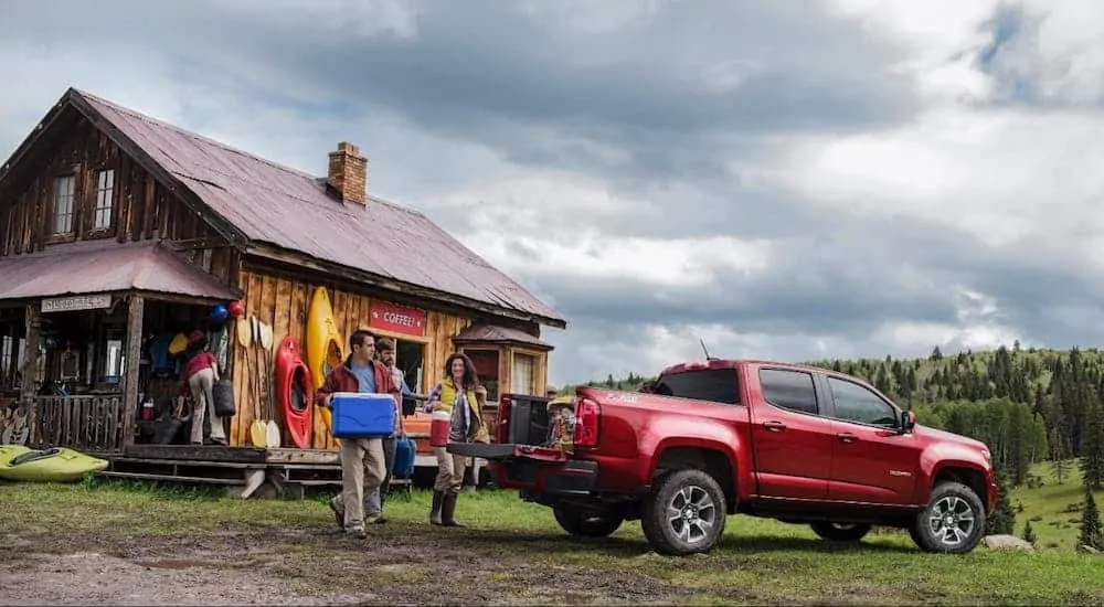 People are loading camping supplies into the bed of a 2017 Chevy Colorado.