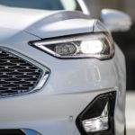 A closeup shows the grille of a white 2020 Ford Fusion.