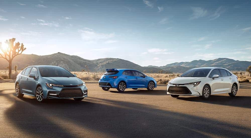 Three versions of the 2021 Toyota Corolla are parked in a desert with distant mountains.