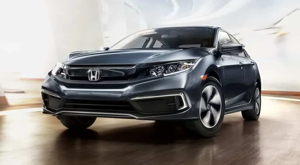 A grey 2019 Honda Civic, which is a popular used car for sale, is driving in a bright white tunnel.