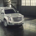 A silver 2016 used Cadillac Escalade is parked in a hanger.