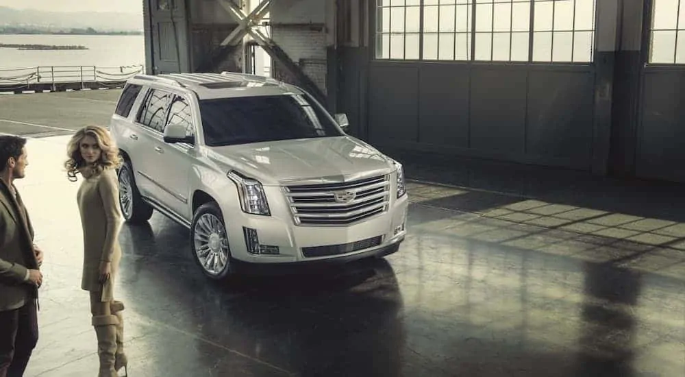 A silver 2016 used Cadillac Escalade is parked in a hanger.