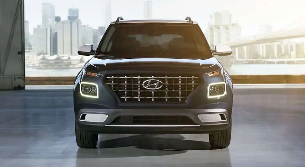 A blue 2021 Hyundai Venue is shown from the front parked in a hangar.
