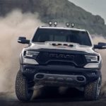A silver 2021 Ram 1500 TRX is off-roading in sand.