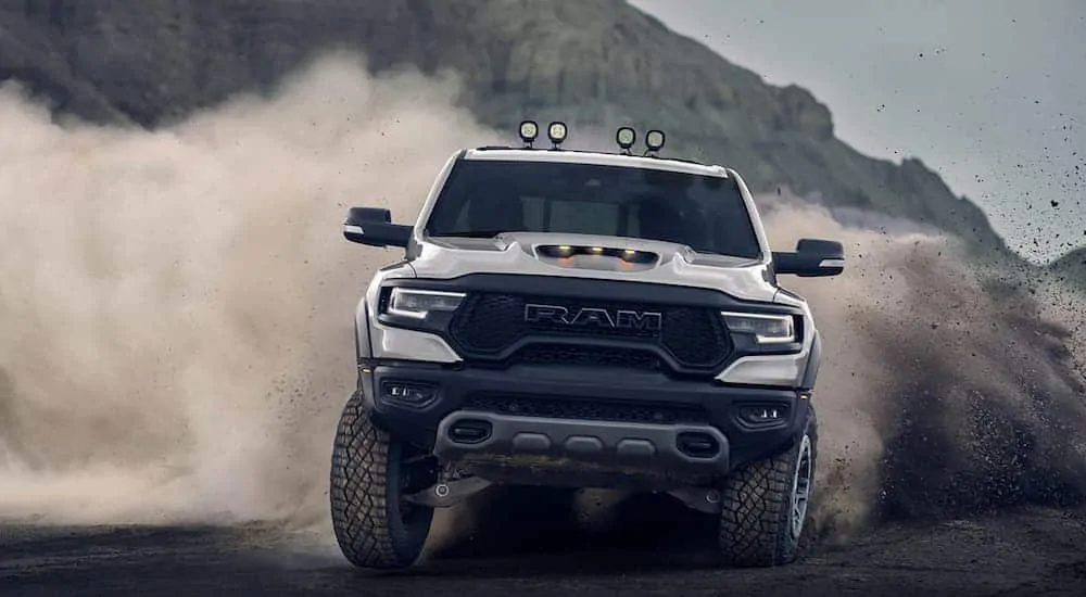 A silver 2021 Ram 1500 TRX is off-roading in sand.