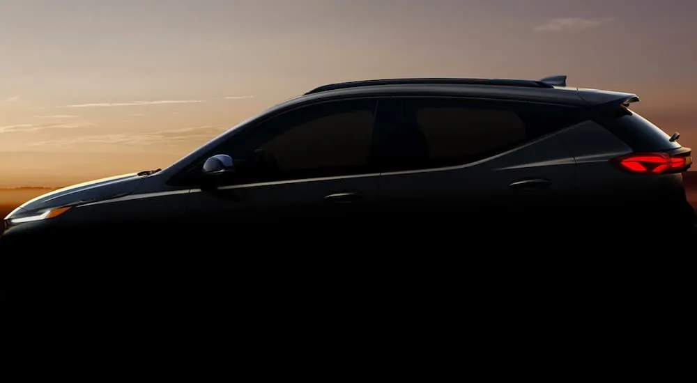 A dark 2022 Chevy Bolt EUV is in front of a sunset.