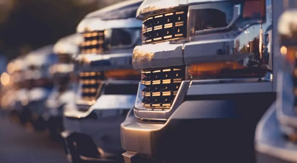 The grilles of several used trucks for sale are shown in closeup.