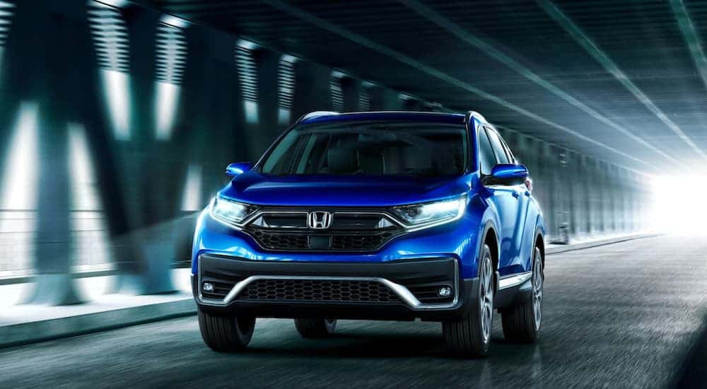 A blue 2020 Honda CR-V is driving through a bridge after winning the 2020 Honda CR-V vs 2020 Toyota RAV4 comparison.
