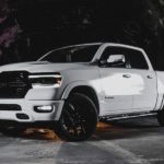 A popular Ram truck, a white 2020 Ram 1500 Laramie Night Edition is parked on the concrete.