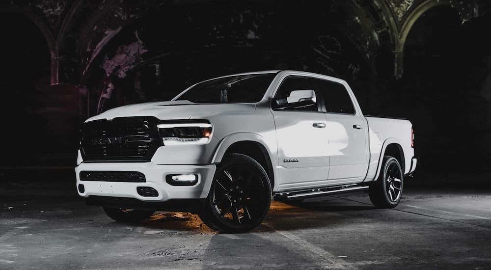 A popular Ram truck, a white 2020 Ram 1500 Laramie Night Edition is parked on the concrete.