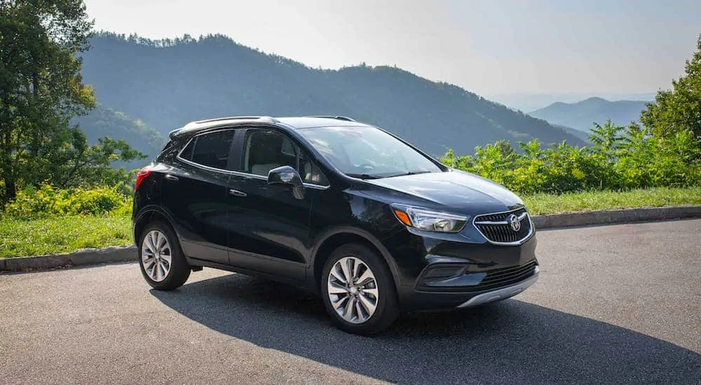 A black 2021 Buick Encore is parked with mountains in the background.