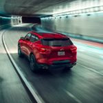 A red 2021 Chevy Blazer is driving down an illuminated tunnel.