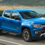 A blue 2021 Chevy Colorado is driving down the road after the 2021 Chevy Colorado vs 2021 Ford Ranger comparison.