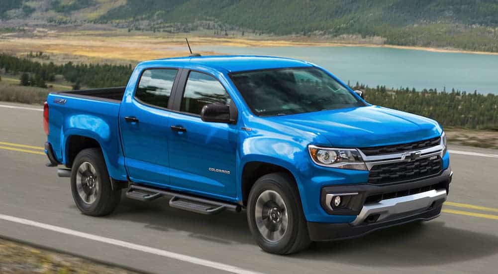 A blue 2021 Chevy Colorado is driving down the road after the 2021 Chevy Colorado vs 2021 Ford Ranger comparison.