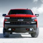 A red 2021 Chevy Silverado 1500 is parked on a salt flat and shown from the front.