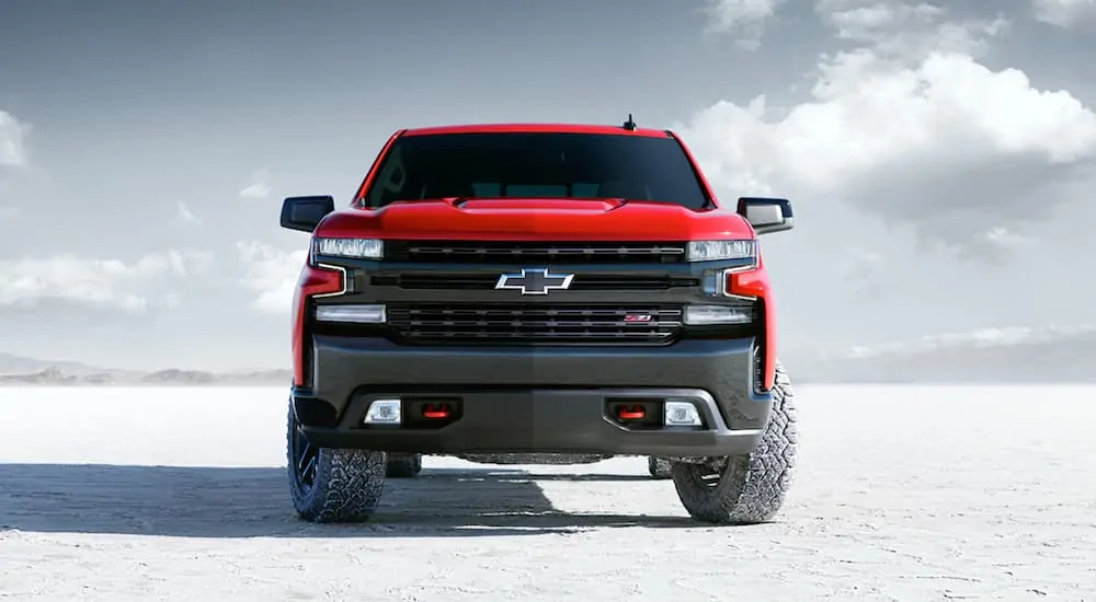 A red 2021 Chevy Silverado 1500 is parked on a salt flat and shown from the front.