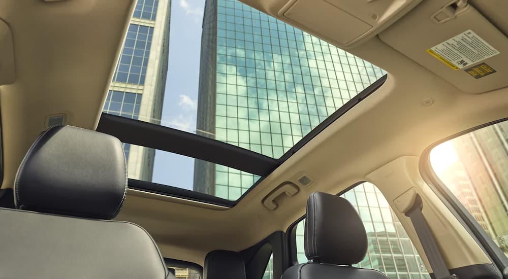 The beige interior and sunroof are shown from a low angle on a 2021 Ford Escape SE.