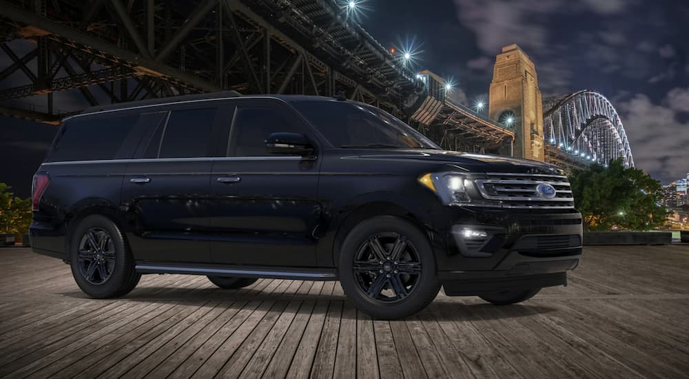 A 2020 Ford Expedition with the black Accent package is shown under a pier at night.
