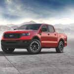 A red 2021 Ford Ranger STX is parked with mist and mountains in the background.