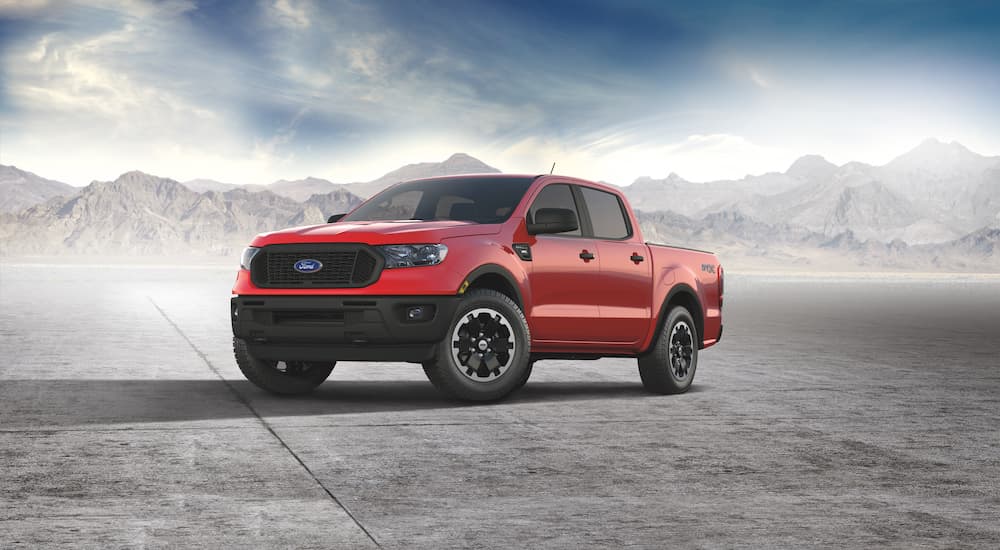 A red 2021 Ford Ranger STX is parked with mist and mountains in the background.
