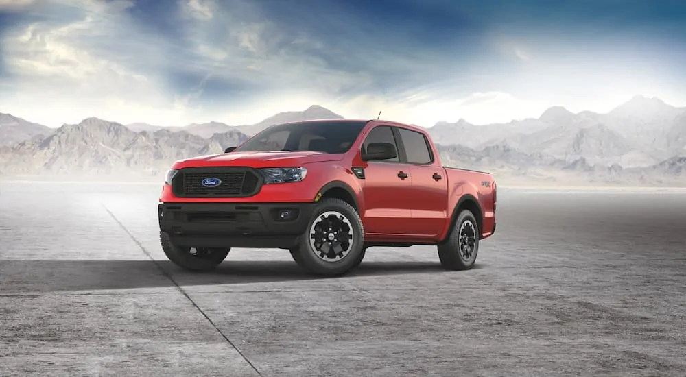 A red 2021 Ford Ranger STX is parked with mist and mountains in the background.