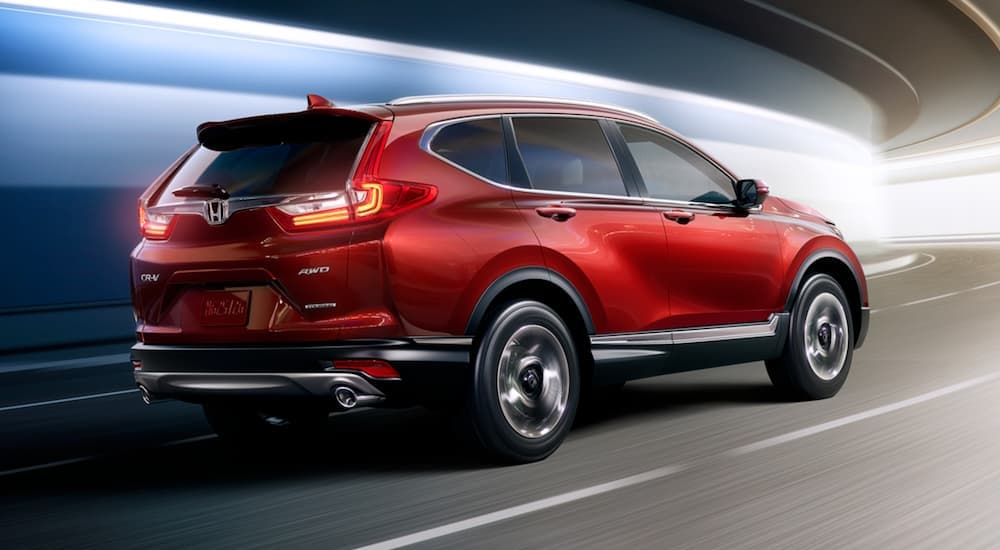A red 2017 Honda CR-V is drivign through a tunnel with blurred lights.