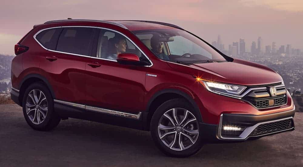 A red 2020 Honda CR-V is parked on a hill overlooking a city.