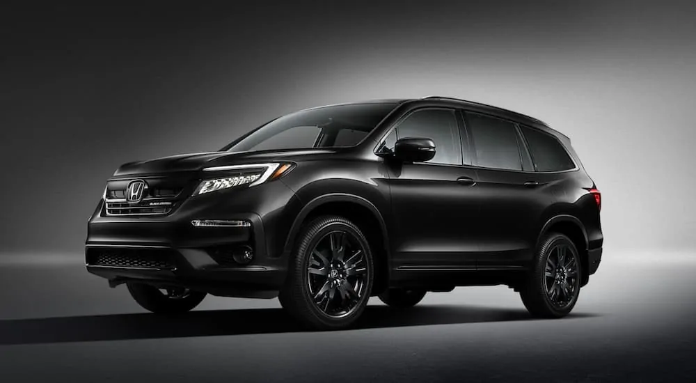 A popular Honda SUV, a black 2021 Honda Pilot Black Edition, is parked angled left.