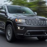 A popular Jeep model, a black 2020 Jeep Grand Cherokee, is driving down a misty mountain road.