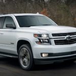 A white 2018 used Chevy Tahoe RST is driving down the highway past blurred trees.
