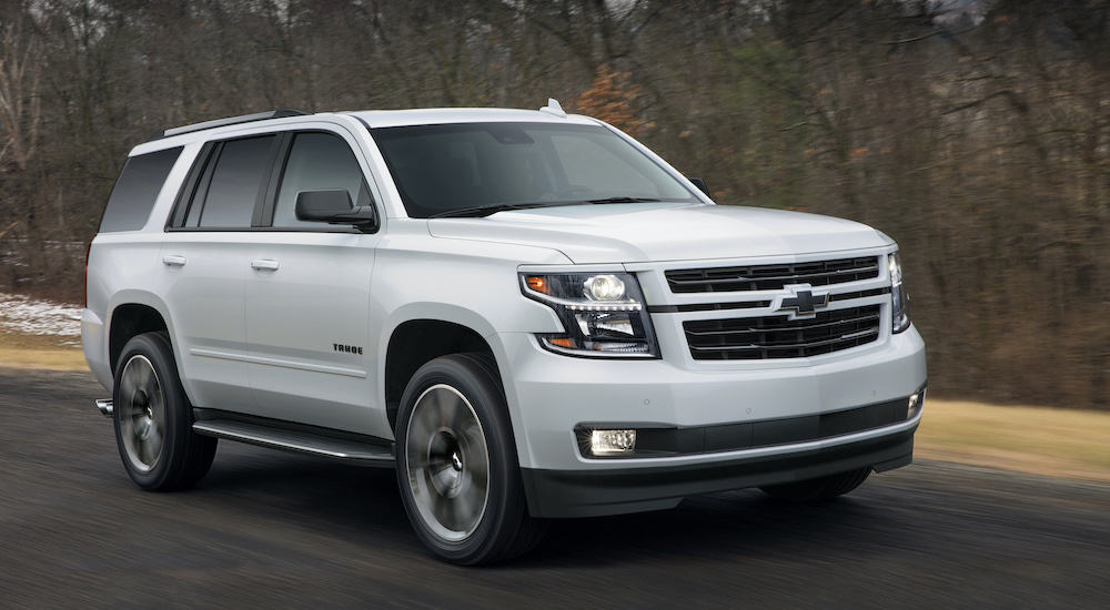 A white 2018 used Chevy Tahoe RST is driving down the highway past blurred trees.