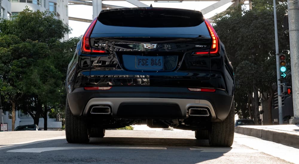 A black 2021 Cadillac XT4 is shown from the rear on a city street.