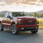 A red 2021 Chevy Silverado 1500 Diesel is parked in front of a farm after winning the 2021 Chevy 1500 Diesel vs 2021 Ram 1500 Diesel comparison.