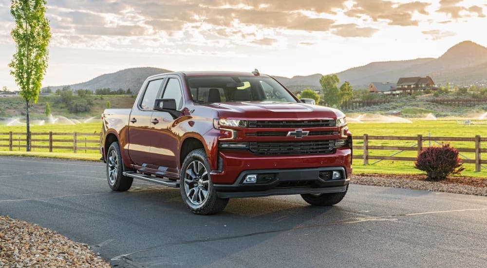 A red 2021 Chevy Silverado 1500 Diesel is parked in front of a farm after winning the 2021 Chevy 1500 Diesel vs 2021 Ram 1500 Diesel comparison.