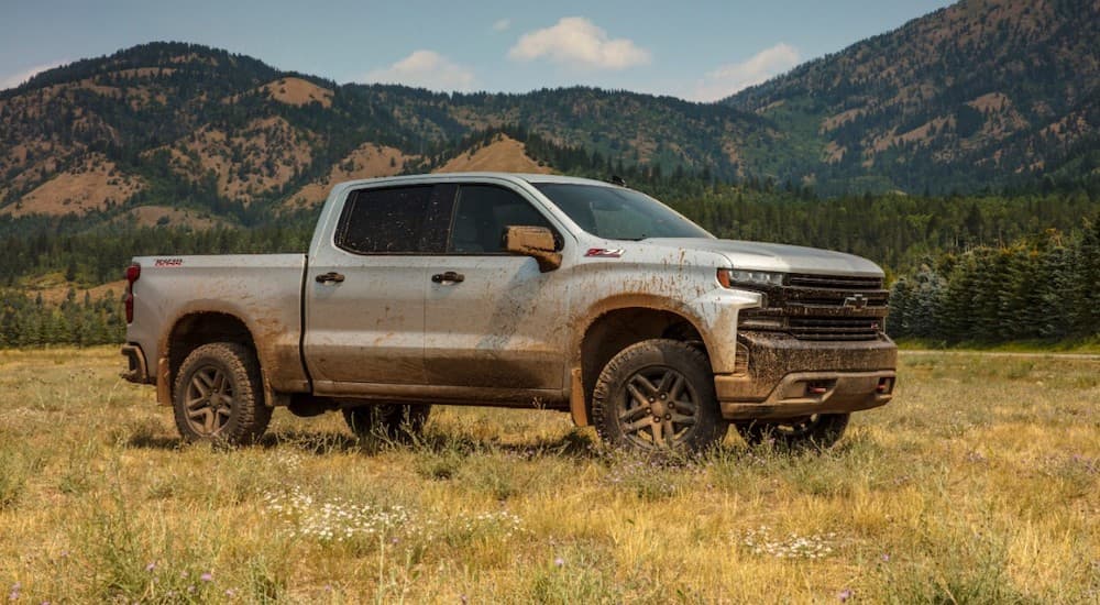 A grey 2021 Chevy Silverado 1500 Trail Boss is in a field covered in mud after winning the 2021 Chevy Silverado 1500 vs 2021 Ram 1500 comparison.