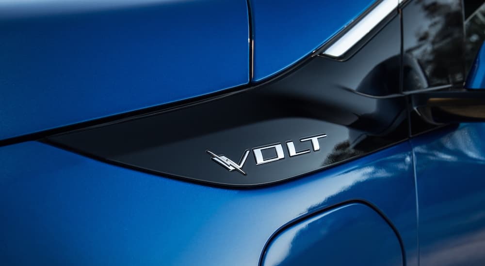 A close up shows the silver emblem on a blue 2016 Chevy Volt.