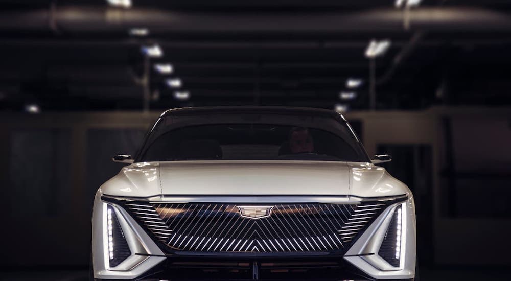 A new GM EV, a white Cadillac Lyriq, is shown from the front in a warehouse.