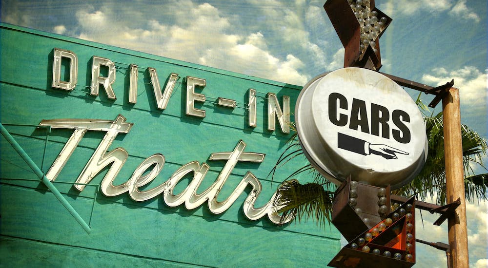 A turquoise sign reads Drive-In Theater and Cars.