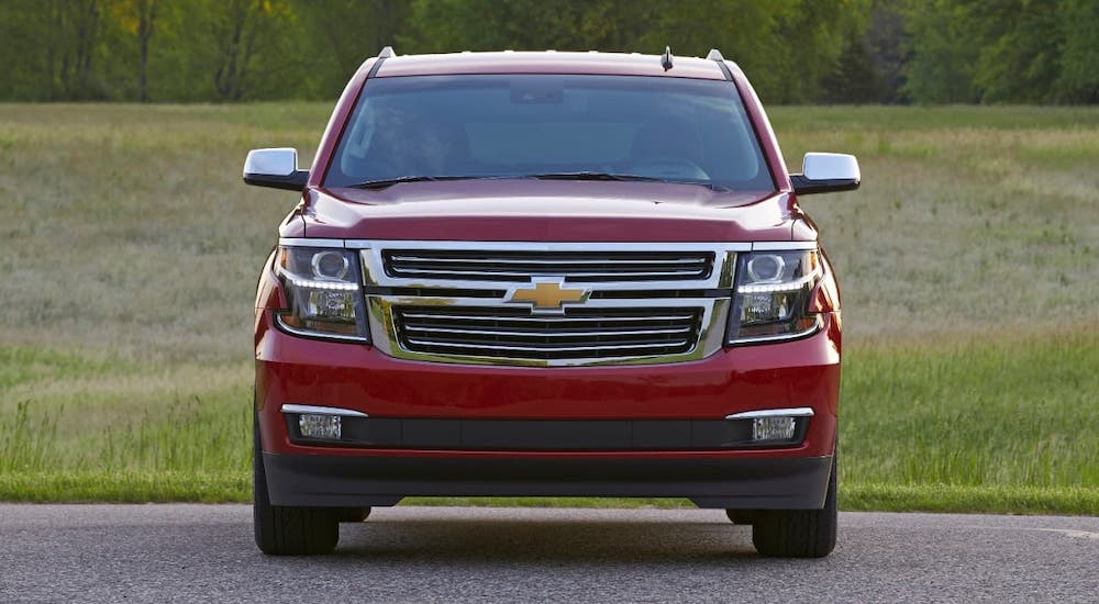 A classic used Chevy Suburban, a red 2015 Suburban LTZ, is shown from the front.