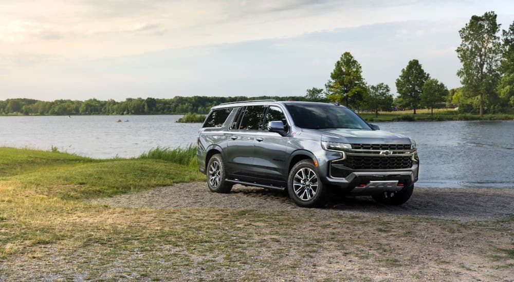 A gray 2021 Chevy Suburban Z71 is parked in front of a lake.