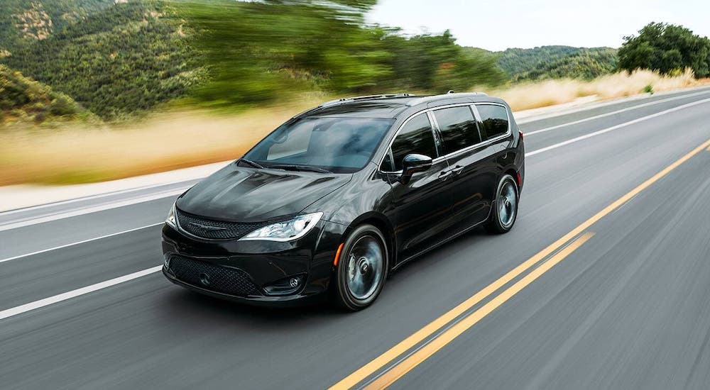 A black 2020 Chrysler Pacifica is driving on a highway after leaving a used Chrysler dealer.