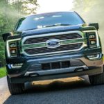 A gray 2021 Ford F-150 Limited is shown from the front driving on a misty road.