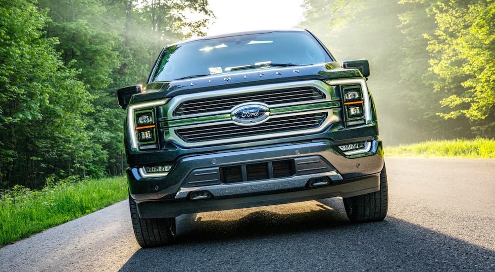 A gray 2021 Ford F-150 Limited is shown from the front driving on a misty road.