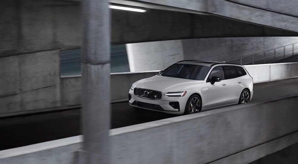 A white 2021 Volvo VC60 is shown driving up a parking garage.