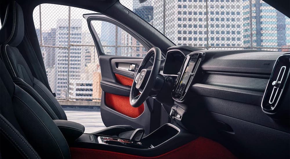 The black and red interior of a 2021 Volvo XC40 is shown from the passenger seat.