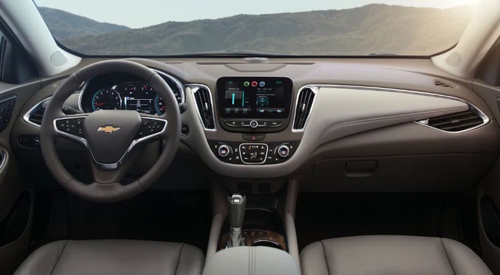The two-tone gray dashboard and steering wheel are shown in a 2021 Chevy Malibu.